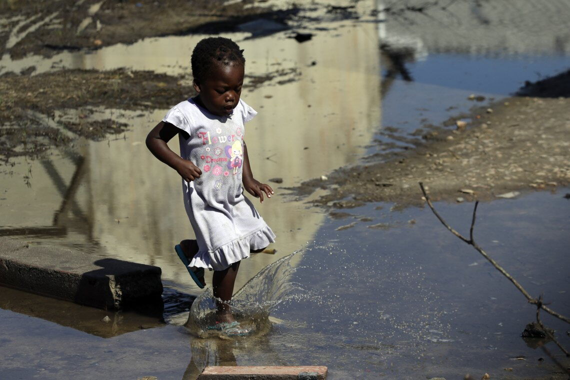 Mädchen auf einer überschwemmten Straße in Beira: Die genaue Zahl der Opfer durch Zyklon Idai ist noch nicht klar.