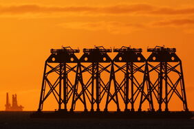 Fundamente für Offshore-Windräder stehen vor der aufgehenden Sonne an der Küste im Nordosten Englands.