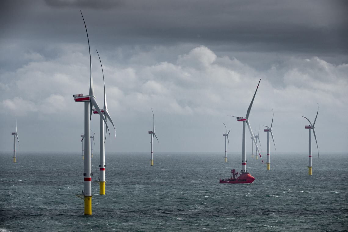 Offshore-Windpark Deutsche Bucht: Ein Schiff fährt bei stürmischem Wetter zwischen den Windrädern hindurch.