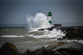 Sassnitz: Hohe Wellen brechen an der Hafenmauer beim Leuchtturm im Sassnitzer Hafen auf Rügen.