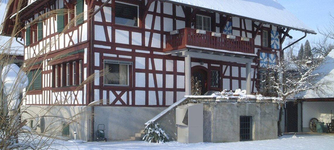 Wärmepumpe vor einem Fachwerkhaus: Die Anlagen heizen auch unsanierte Altbauten vergleichsweise effizient.