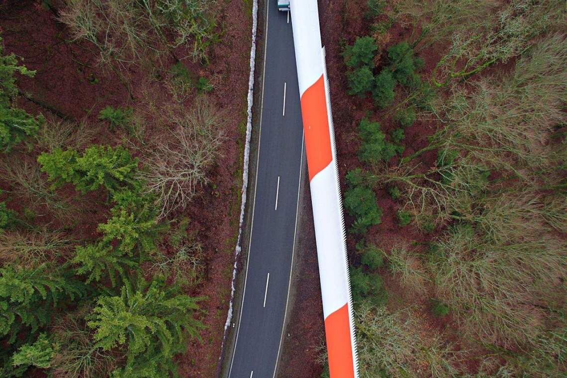 Aus der Vogelperspektive wird die Schwierigkeit beim Transport der langen Rotorblätter durch Waldstücke noch einmal besonders deutlich: Selbst wenn die Kurven so langgestreckt sind wie hier würde das Blatt beim Ausscheren gegen die Bäume stoßen.