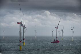 Offshore-Windpark Deutsche Bucht: Ein Schiff fährt bei stürmischem Wetter zwischen den Windrädern hindurch.