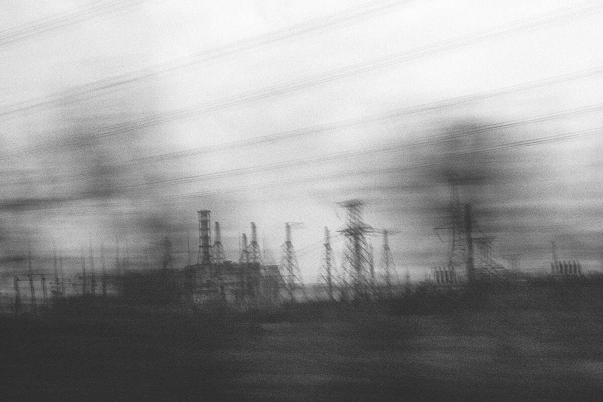 Schemenhaft sind Strommasten und im Hintergrund das Atomkraftwerk Tschernobyl zu sehen. Foto: Arthur Bondar.