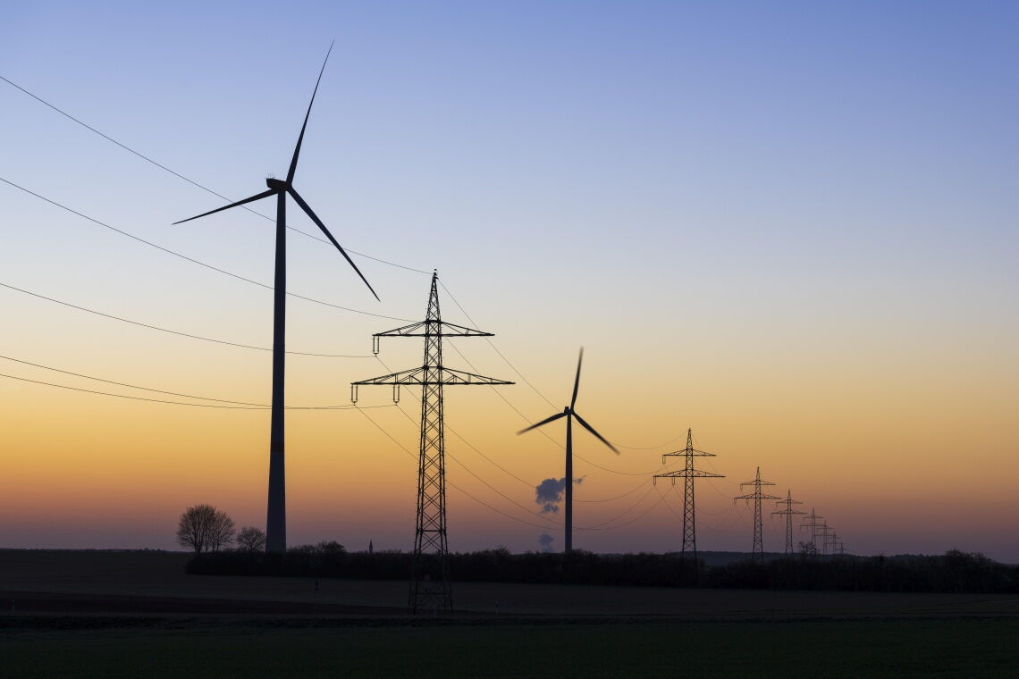 Strommasten und Windräder entlang einer Freileitung: Bei kühlem Wetter könnten die Drähte mehr Strom transportieren – wenn die Temperatur denn gemessen würde.