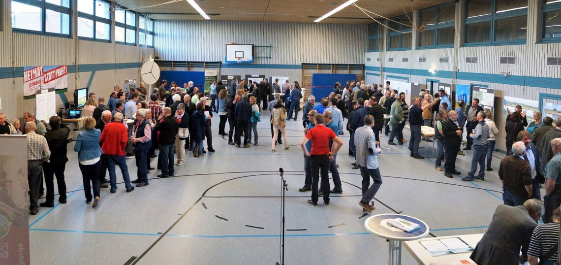 In Turnhallen wie diesen entscheidet sich die Energiewende: Rund 200 Besucher diskutieren Mitte Mai in Pfronstetten über die Pläne zum Bau von Windrädern. An Infoständen informieren die verschiedenen Parteien über ihre Standpunkte. Ganz links: die Bürgeri