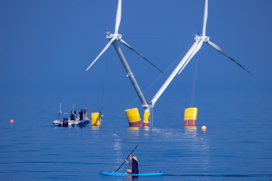 Stand-up-Paddlerin im Greifswalder Bodden vor dem Modell Nezzy2: Das Windrad mit seinen zwei Rotoren könnte die schwimmende Windenergie (Floating Wind) revolutionieren.