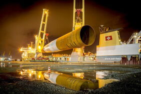 Verladung des Fundaments (Monopile) eines Offshore-Windrads auf ein Schwerlastschiff.