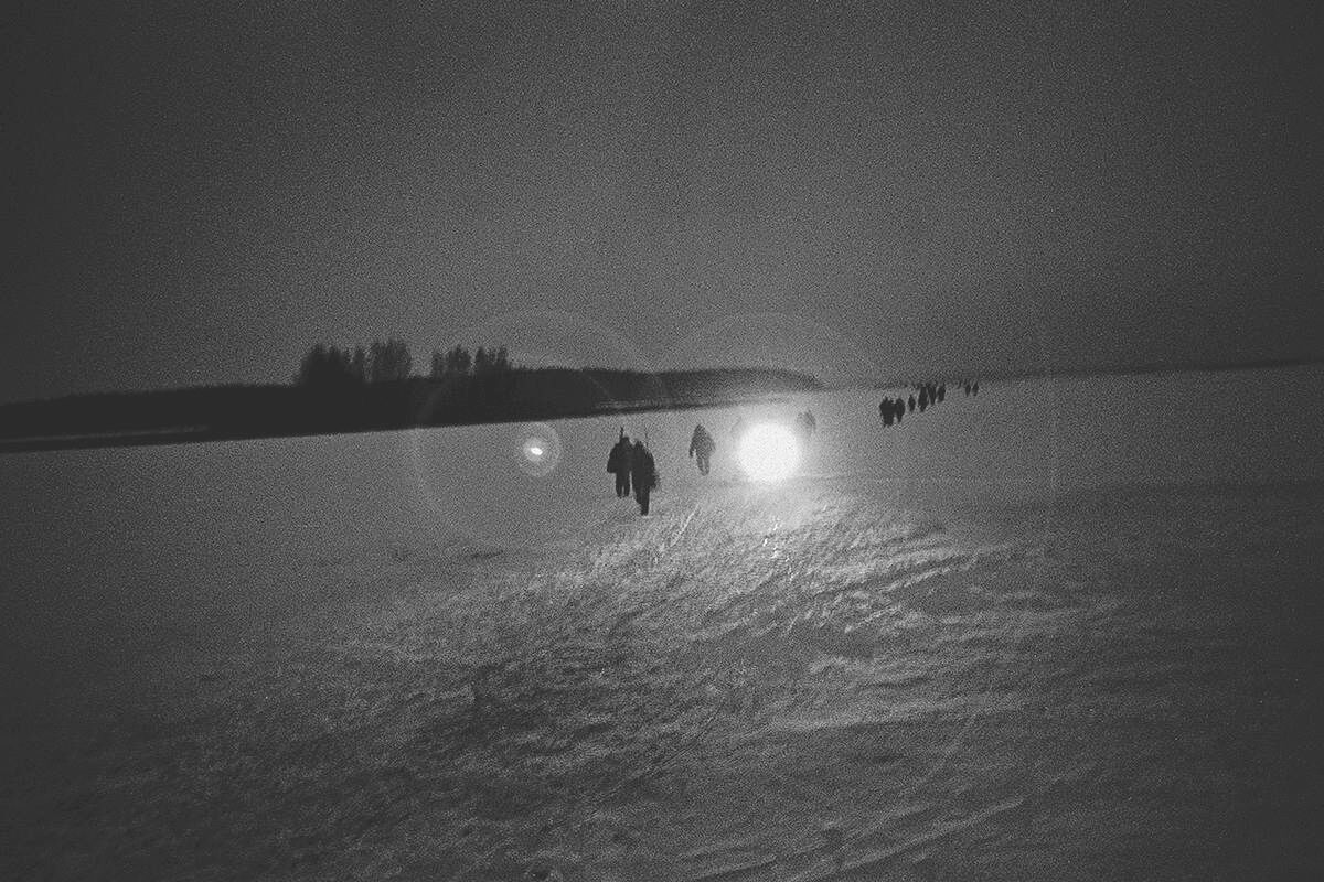 Fischer aus einem Dorf nahe der Sperrzone von Tschernobyl kehren über einen zugefrorenen Fluss nach Hause zurück. Foto: Arthur Bondar.
