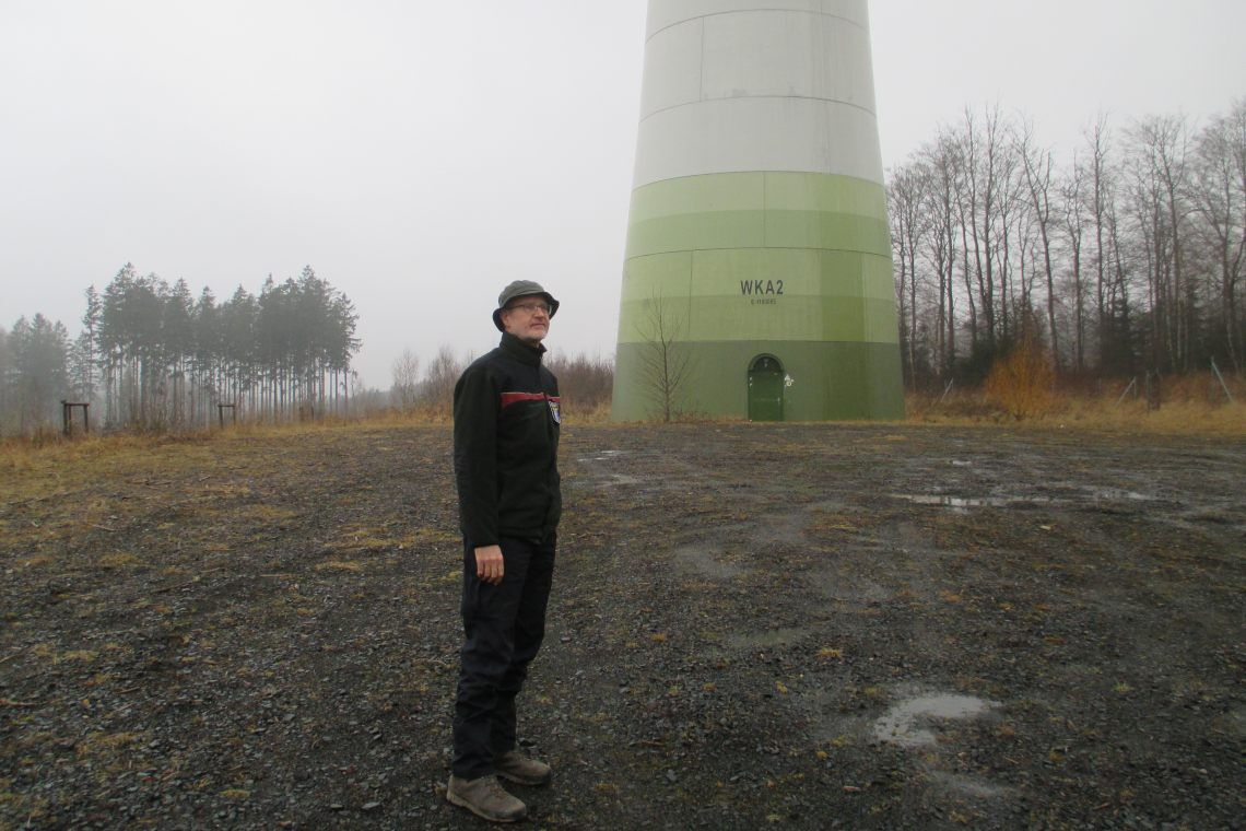 Förster Günter Groß vor einem Windrad im Kaufunger Wald (Hessen): „Die Monokulturen werden zum Märchenwald verklärt.“