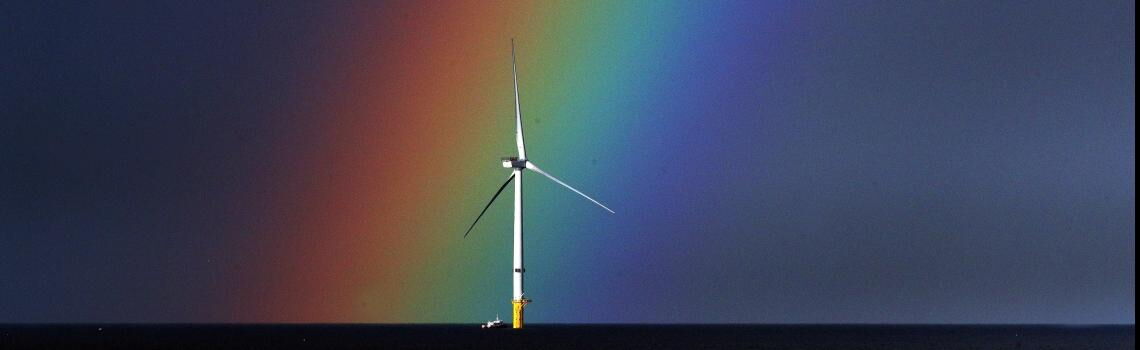 Offshore-Windrad vor spektakulärem Regenbogen, fotografiert vor der Küste von Blyth, Northumberland.