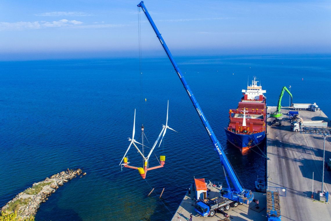 Ein gigantischer Kran hebt das Modell Nezzy2 vom Hafen auf die Ostsee. Das Floating-Wind-Modell soll die Offshore-Windenergie revolutionieren.