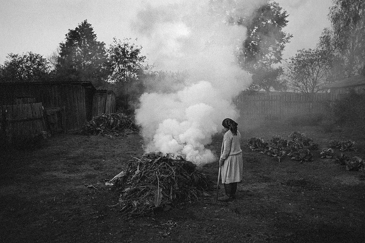 Eine Frau verbrennt Gartenabfälle in einem Dorf am Rand der Sperrzone von Tschernobyl: Umweltschützer warnen davor, Feuer zu entzünden – der Rauch könnte radioaktives Material verbreiten.