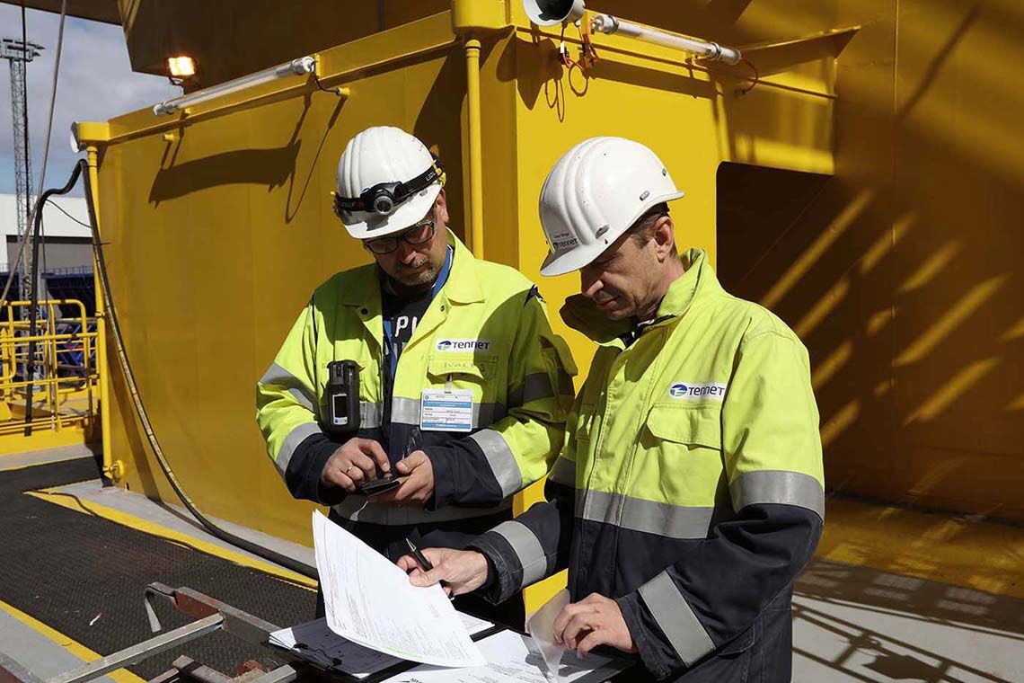 Konverterstation Dolwin Gamma: Zwei Tennet-Mitarbeiter stehen auf dem Topdeck der Anlage.